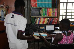 A Form Three student borrows a book from the Amani Kibera Library in Lindi, Kibera.