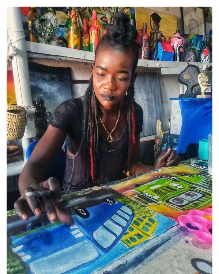 Faith Atieno ,visual artist and founder of Art 360 kibera working on a piece of art.